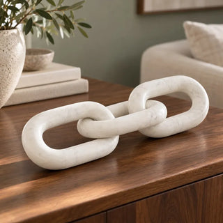 Marble chain sculpture white on walnut sideboard beside olive branch vase