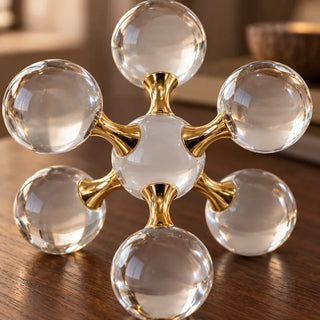 Molecular crystal ball ornament gold connectors close up on dark wood table