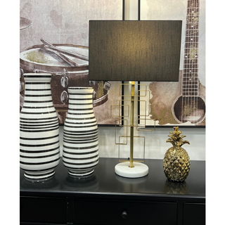 Designer marble-base table lamp silver gold metal stand beside decorative vases.