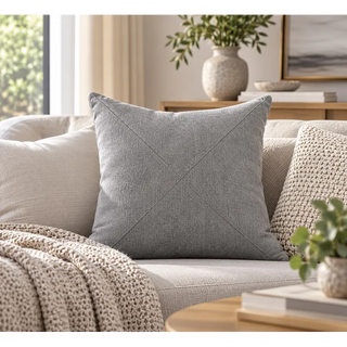 Pebble grey textured cushion on cream sofa with chunky knit throw