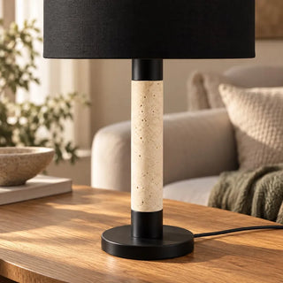 Raffle lamp with travertine stone and black shade column close up on oak table