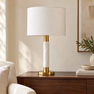Raffle table lamp on walnut sideboard in daylight beside cream armchair