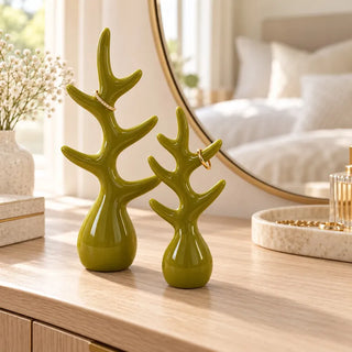 Ring holder in spring green on oak dresser beside round gold mirror