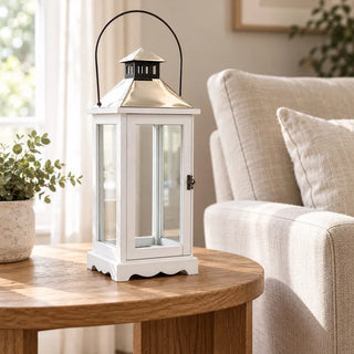 Rustic wooden lantern on round oak side table beside linen armchair
