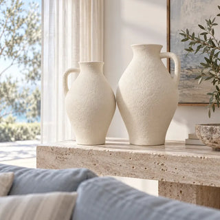 Sandroot vase with handle pair on travertine console behind blue sofa