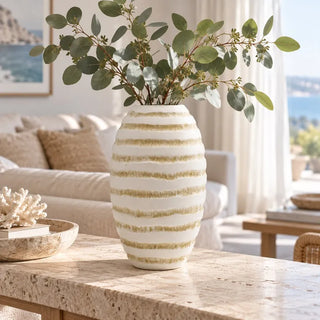 Seawhite wavy pattern vase with eucalyptus on travertine coffee table beside coral