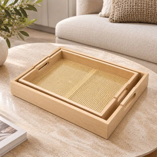 Set of 2 stackable wooden trays on round travertine coffee table beside cream sofa