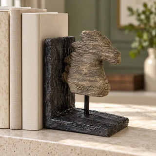 Shadow horse head bookend sculpture close up with cream books on travertine ledge