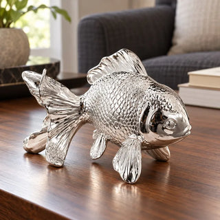 Silver metallic fish figurine on walnut coffee table beside charcoal sofa