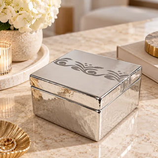 Silver square treasure box on cream marble table with white hydrangeas