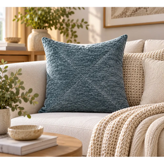 Slate teal textured cushion on cream sofa with chunky knit throw