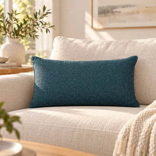 Teal woven cushion on cream sofa with knit throw and olive branches