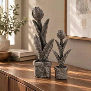 Tulip flower sculpture small and tall on walnut sideboard beside framed artwork