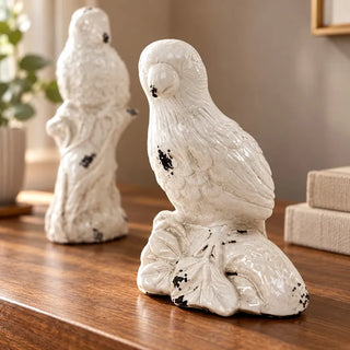 Vintage white ceramic parrot statues leaf base bird close up on walnut tabletop