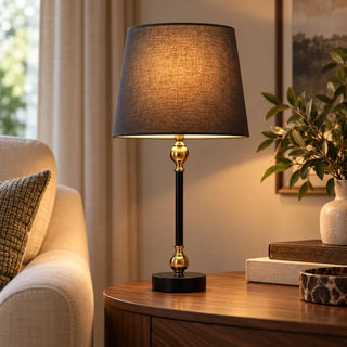 Windsor candlestick table lamp on round walnut side table beside cream armchair